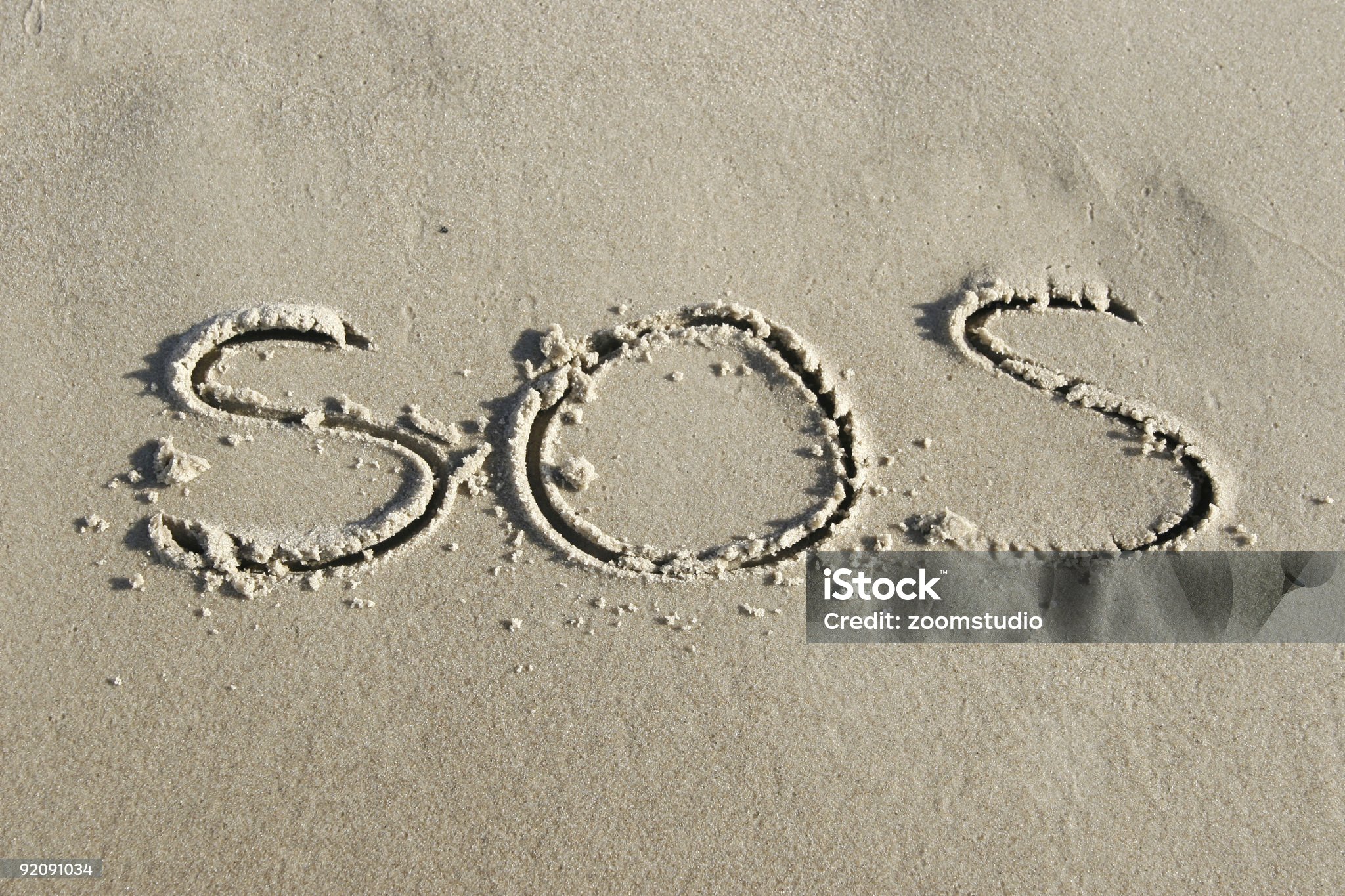 SOS skrevet i sanden